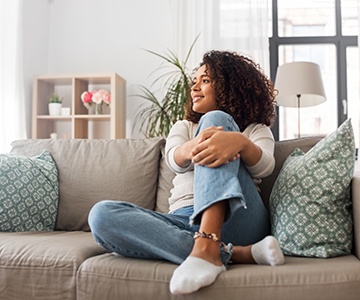 a smiling woman relaxing on a couch