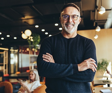 a smiling man with his arms crossed